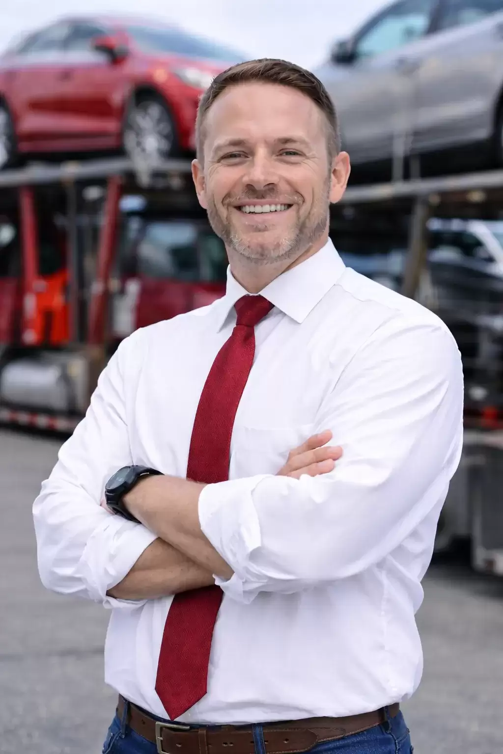 Colorado businessman in front of auto transport carrier