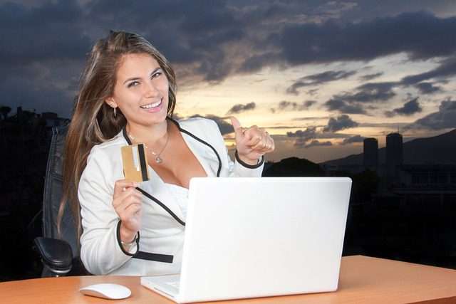 Photo of pretty woman online buying a car with laptop