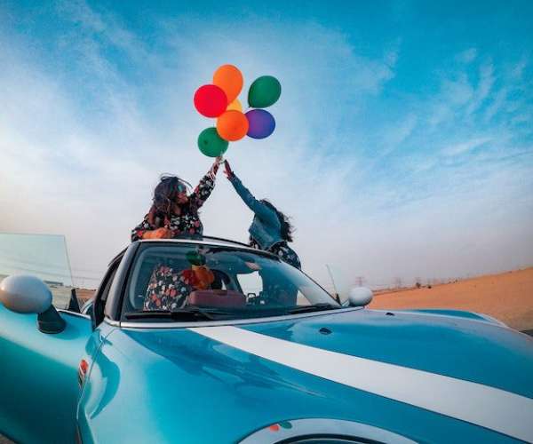 photo of couple celebrating in a convertible auto transport rates