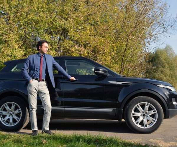 photo of Man leaning on a SUV before car shipping