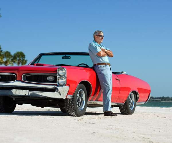 Snowbird Auto Transport Older Gentleman Leaning On Red Convertible