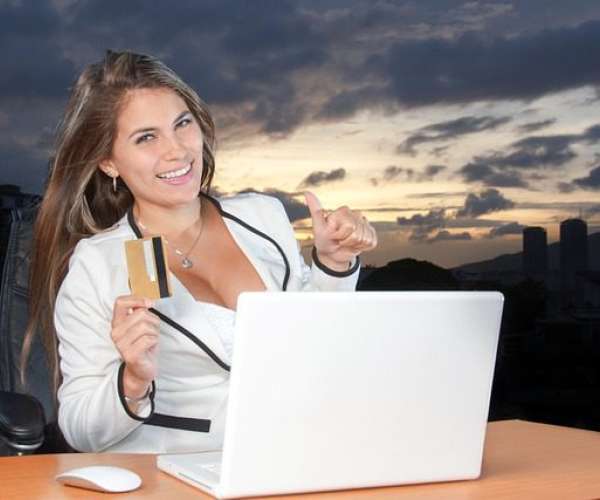 Photo of pretty woman online buying a car with laptop