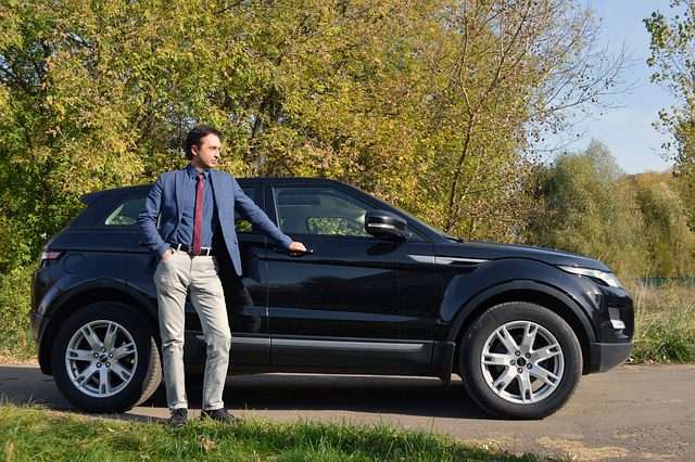 photo of Man leaning on a SUV before car shipping