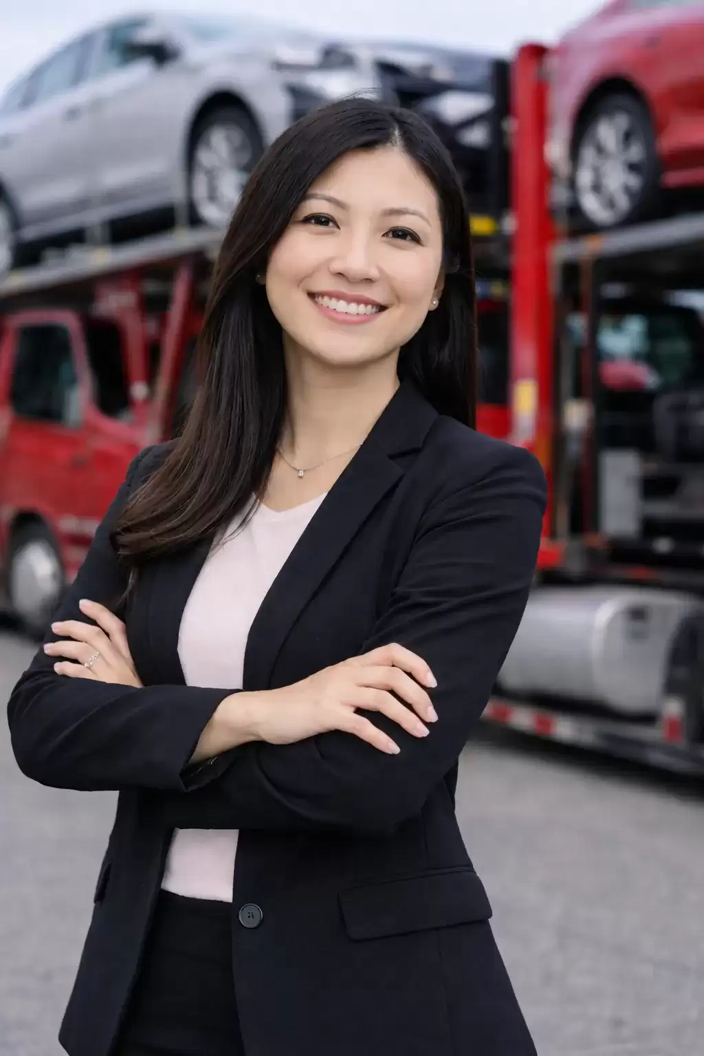 Arkansas business woman in front of a full car carrier